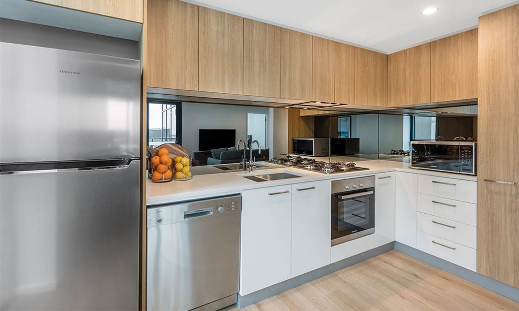 Full modern kitchen equipped with fridge, cook top, over and microwave