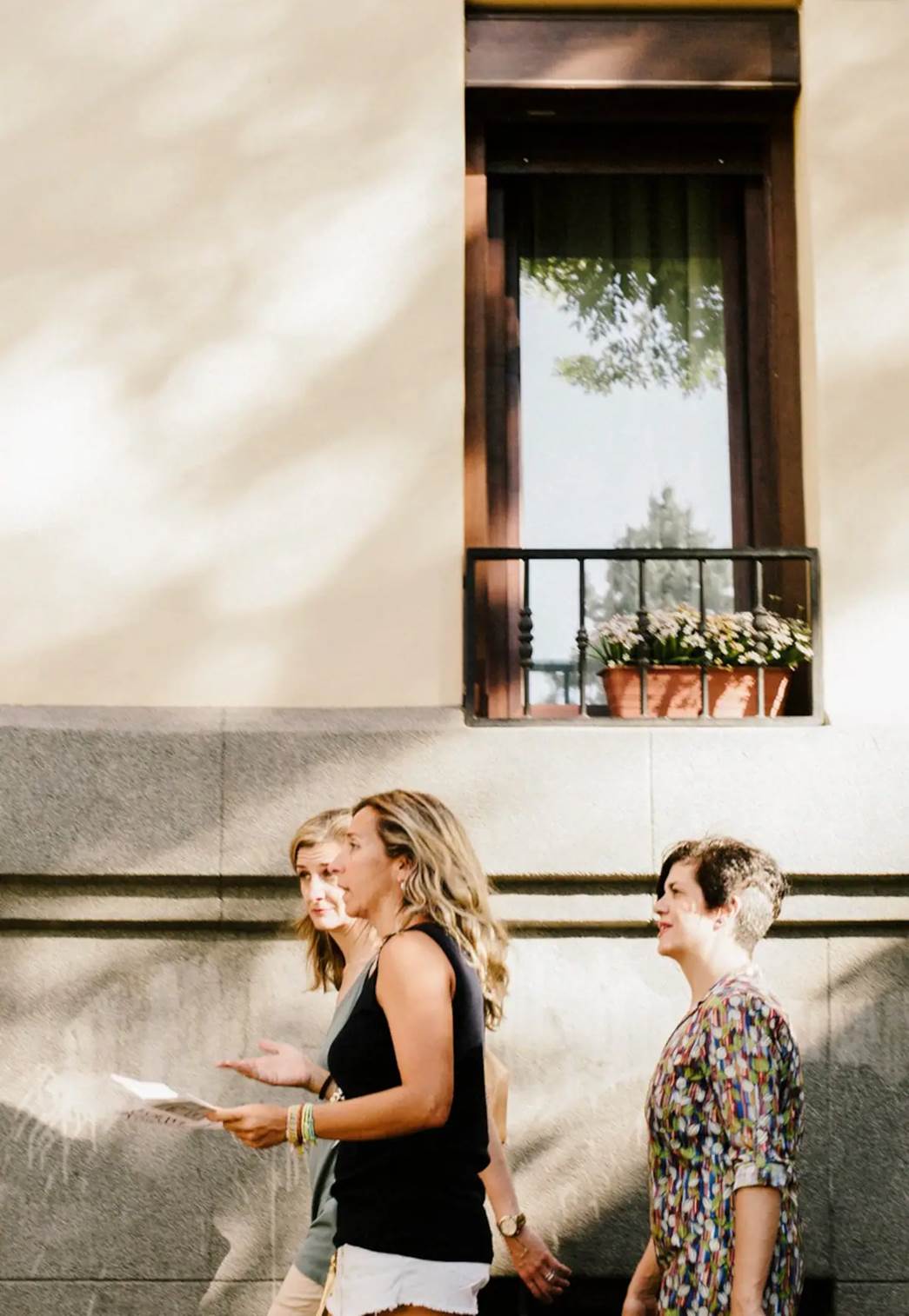 A group of three walking on the streets of Madrid.