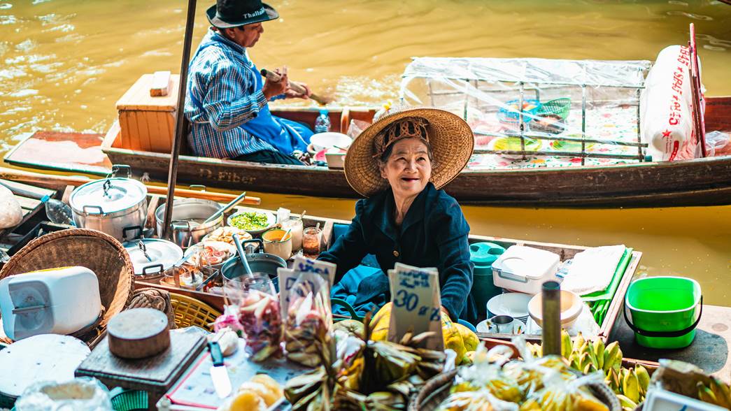 A merchant woman on a boat in a floating market.