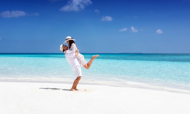 Avani+ Fares Maldives Resort couple enjoying the tropical weather and sandy beach